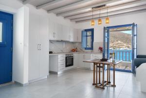 a kitchen with white cabinets and a table in a room at Nicolas House 4 in Rakhídhion +19 photos