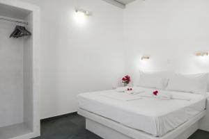 a white bed in a white room with flowers on it at Nicolas House 4 in Rakhídhion