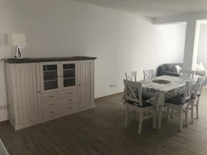 a dining room with a table and chairs and a cabinet at Ferienwohnung, 110qm in Hohen Wangelin +10 photos