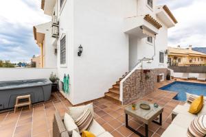 a patio with a hot tub and a swimming pool at Casa Ohana Fuengirola in Fuengirola