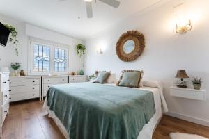 a white bedroom with a bed and a mirror at Casa Ohana Fuengirola in Fuengirola +37 photos