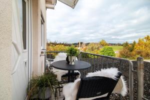 a balcony with a table and chairs with a view at Fewo Christi in Weißensberg