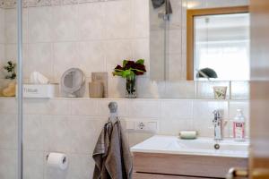 a bathroom with a sink and a mirror at Fewo Christi in Weißensberg +13 photos