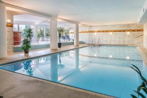 a pool in a hotel room with a large swimming pool at Weitblick in Uhldingen-Mühlhofen
