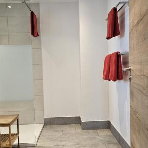 a bathroom with two red towels hanging on a wall at wohnung-nummer-4 in Pielenhofen +3 photos
