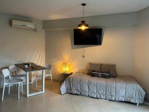 a bedroom with a bed and a table and a television at Monoambiente 1 Village Golf in Yerba Buena