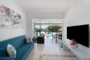 a living room with a blue couch and a tv at Villa Milena in Callao Salvaje