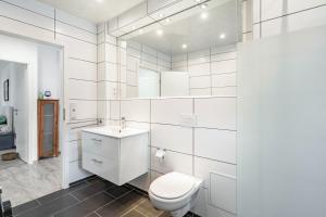 a white bathroom with a toilet and a sink at Ferienwohnung am Residenzschloss in Altenburg +15 photos
