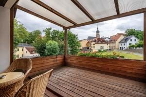 a balcony with a wooden deck with a table and chairs at Ferienwohnung am Residenzschloss in Altenburg