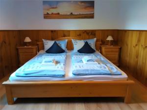 a bed with blue and white pillows on it at Ferien Auf Dem Steingrubenhof in Sankt Peter