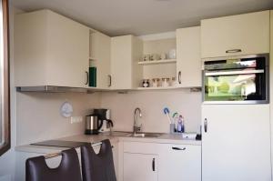 a kitchen with white cabinets and a white refrigerator at Ferien Auf Dem Steingrubenhof in Sankt Peter