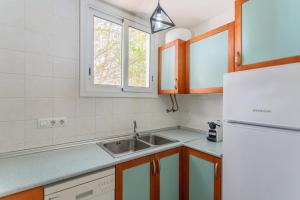 a kitchen with a sink and a refrigerator at Casa Yves in Tossa de Mar