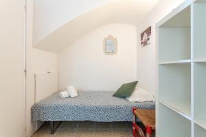 a small bedroom with a bed in a white room at Casa Yves in Tossa de Mar