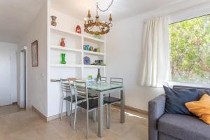 a dining room with a glass table and a couch at Casa Yves in Tossa de Mar