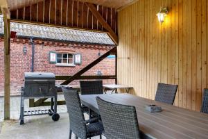 a patio with a table and chairs and a grill at Grodenhof in Norderschwei