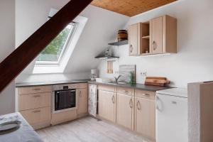 a kitchen with wooden cabinets and a window at Grodenhof in Norderschwei +17 photos