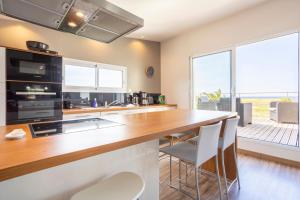 a kitchen with a counter and a large window at Maison Horizon - 3 ch - 100m plage in Le Guilvinec