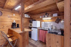 a kitchen with white appliances and wooden walls at Petite maison de bois in Banyuls-dels-Aspres