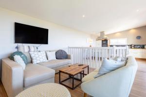 a living room with two couches and a tv at Maison Horizon - 3 ch - 100m plage in Le Guilvinec