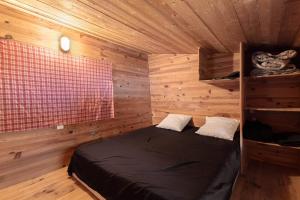 a bedroom with a bed in a wooden room at Petite maison de bois in Banyuls-dels-Aspres