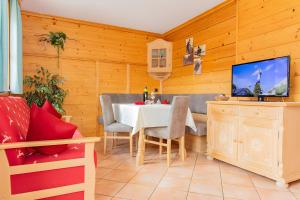 a dining room with a table and a tv at Blockhaus Ganschitter Großarl in Grossarl