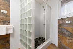 a shower with a glass block wall in a bathroom at El Altillo House in Moya +26 photos