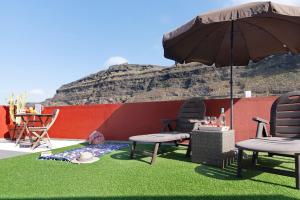a patio with two chairs and an umbrella at El Altillo House in Moya