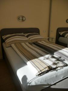 a bed with a striped blanket on top of it at Am Kiefernweg 17 in Schwielochsee