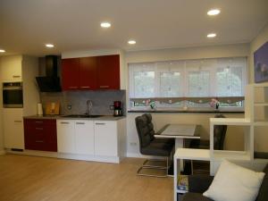 a kitchen with red cabinets and a table in a room at Am Kiefernweg 17 in Schwielochsee