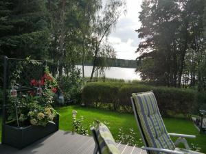 a deck with chairs and a view of a lake at Am Kiefernweg 17 in Schwielochsee