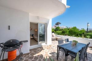 a patio with a grill and a table and chairs at Rocas del Mar in Mijas