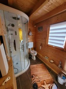 a wooden bathroom with a shower and a toilet at Ferienhaus Seeblick in Nöda +14 photos