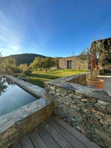 a stone retaining wall next to a pool of water at Chambres d'hote Bergerie A Maredda in Murato