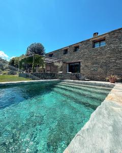 a pool of water in front of a building at Chambres d'hote Bergerie A Maredda in Murato