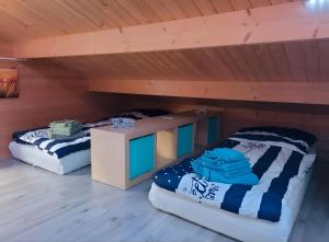 two beds in a room with wooden ceilings at Ferienhaus Seeblick in Nöda