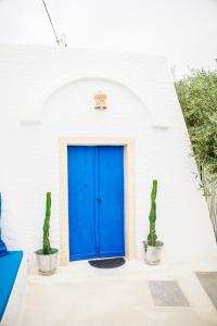 a blue door in a white building with two cactus at Menzel LellaMina in Houmt Souk