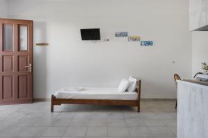 a bedroom with a bed and a tv on a wall at Frantzis Studio 2 - Nisyros in Páloi