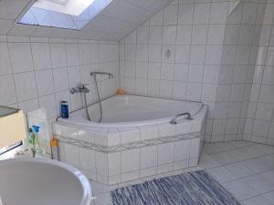 a white bathroom with a tub and a sink at Hof Schumacher in Gumtow +15 photos