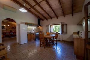a kitchen with a table and chairs and a refrigerator at Cugulutx in Llucmajor