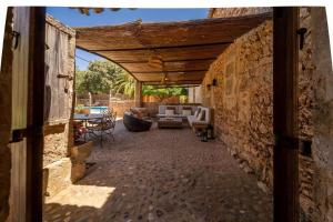 an entrance to a patio with a stone wall at Cugulutx in Llucmajor +11 photos