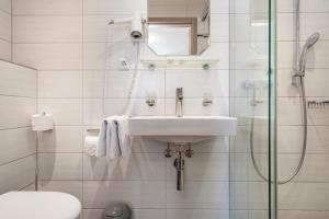 a white bathroom with a sink and a shower at Gasthof Adler in Ebenweiler +72 photos