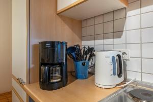 a kitchen counter with a coffeemaker and a coffee maker at Haus Gisela - Stockkamp in Todtmoos