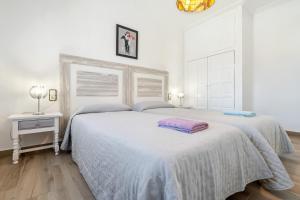 a white bedroom with two beds and a table at Palmera in Miami Platja +13 photos