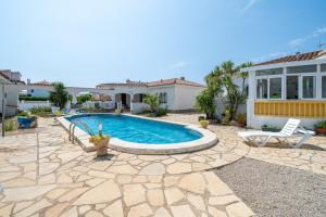 a backyard with a swimming pool and a house at Palmera in Miami Platja