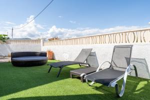 two chairs and a bench on a lawn at Palmera in Miami Platja