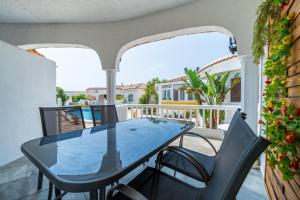 a patio with a glass table and chairs on a balcony at Palmera in Miami Platja
