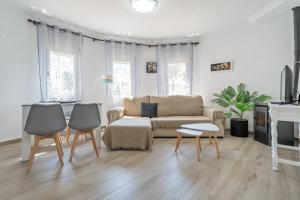 a living room with a couch and two chairs at Palmera in Miami Platja