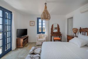 a bedroom with a bed and a flat screen tv at Villa Agios Sostis in Serifos Chora