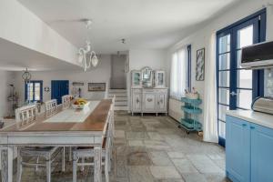 a kitchen with blue cabinets and a table with chairs at Villa Agios Sostis in Serifos Chora