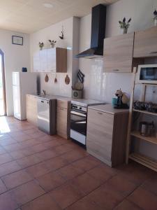 a kitchen with white appliances and a tile floor at Can Joan in Rosell